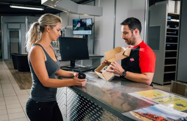 Femme agricultrice qui commande ses pièces d'origine KUHN chez son concessionnaire