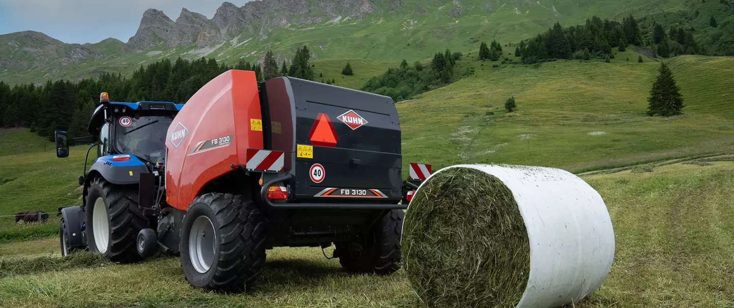 La rotopressa fissa KUHN FB 3130 con legatura a pellicola produce rotoballe in montagna